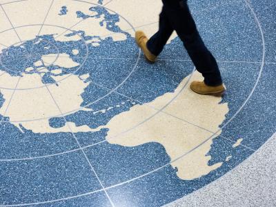 legs walking across a world map on the floor