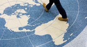 legs walking across a world map on the floor